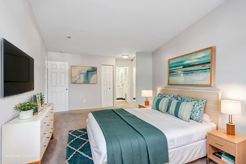 A bedroom with a bed, nightstand, and a painting on the wall. at Millennium at Creve Coeur, Missouri, 63141